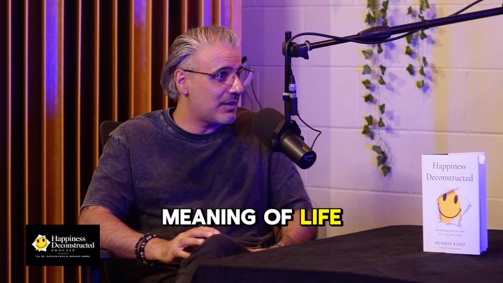 Hussein Kanji speaking into a microphone on Human Deconstructed